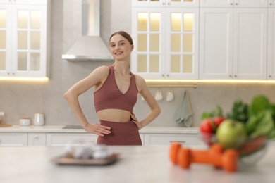 Photo of Slim woman in sportswear posing in kitchen, selective focus