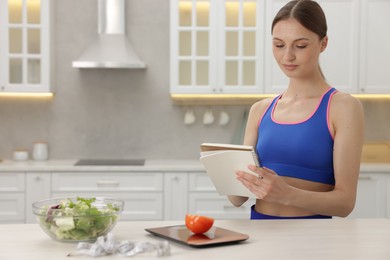 Photo of Woman developing diet plan at white table indoors, space for text