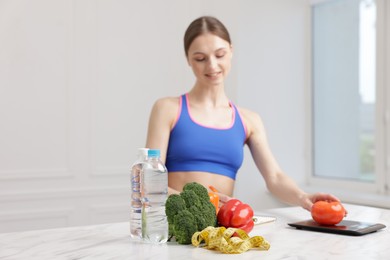 Photo of Woman developing diet plan at white marble table indoors, selective focus