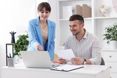 Photo of Consultant working with client at table in office. Business meeting