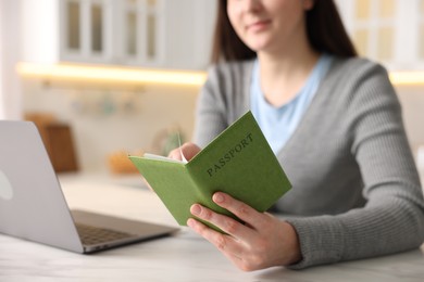 Photo of Woman with passport at white marble table indoors, closeup