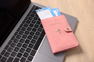 Photo of Passport, flight tickets and laptop on wooden table, above view