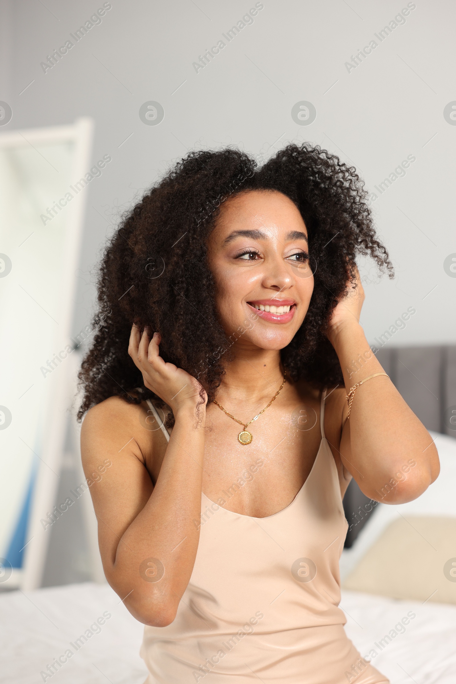 Beautiful smiling Brazilian woman with curly hair indoors Photo of Beautiful smiling Brazilian woman with curly hair indoors