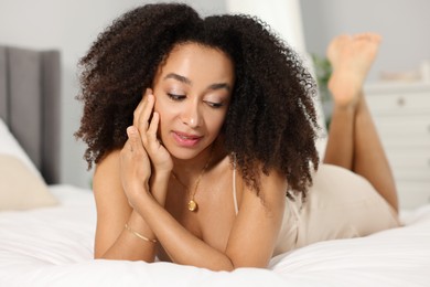Photo of Beautiful Brazilian woman lying on bed indoors