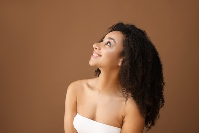 Photo of Portrait of beautiful Brazilian woman on light brown background, space for text