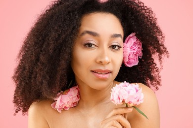 Photo of Beautiful Brazilian woman with peonies on pink background