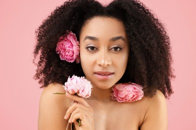 Photo of Beautiful Brazilian woman with peonies on pink background