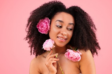Photo of Beautiful Brazilian woman with peonies on pink background