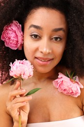 Photo of Beautiful Brazilian woman with peony flowers, closeup