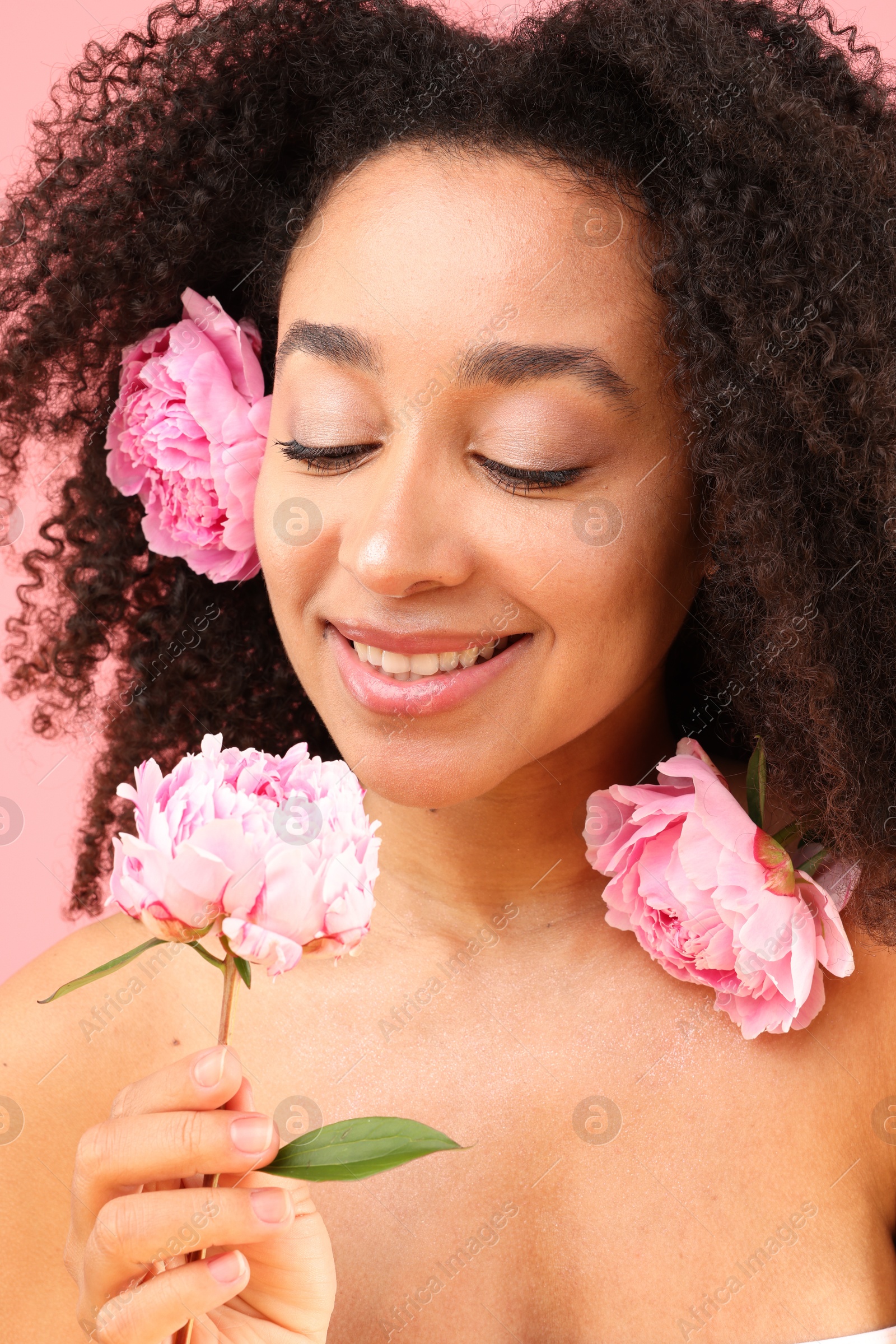 Beautiful Brazilian woman with peonies on pink background, closeup Photo of Beautiful Brazilian woman with peonies on pink background, closeup
