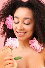 Photo of Beautiful Brazilian woman with peonies on pink background, closeup