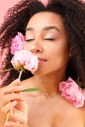 Photo of Beautiful Brazilian woman with peonies on pink background, closeup