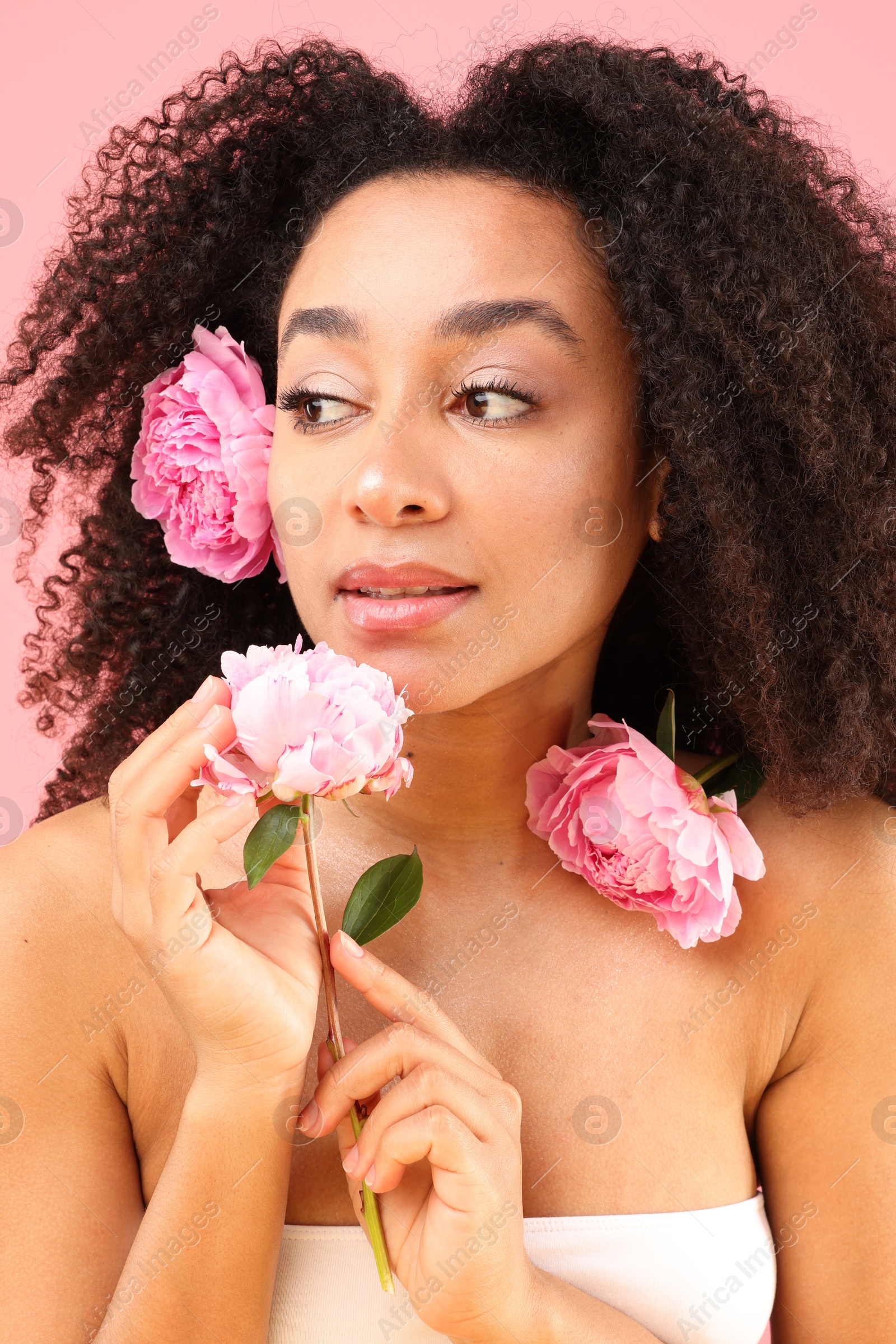 Beautiful Brazilian woman with peonies on pink background, closeup Photo of Beautiful Brazilian woman with peonies on pink background, closeup