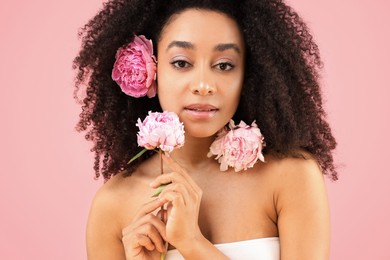 Photo of Beautiful Brazilian woman with peonies on pink background