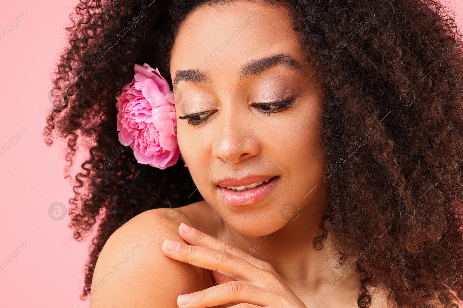 Beautiful Brazilian woman with peony flower on pink background, closeup Photo of Beautiful Brazilian woman with peony flower on pink background, closeup