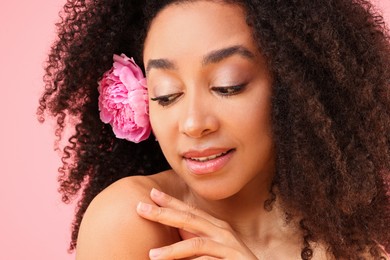 Photo of Beautiful Brazilian woman with peony flower on pink background, closeup