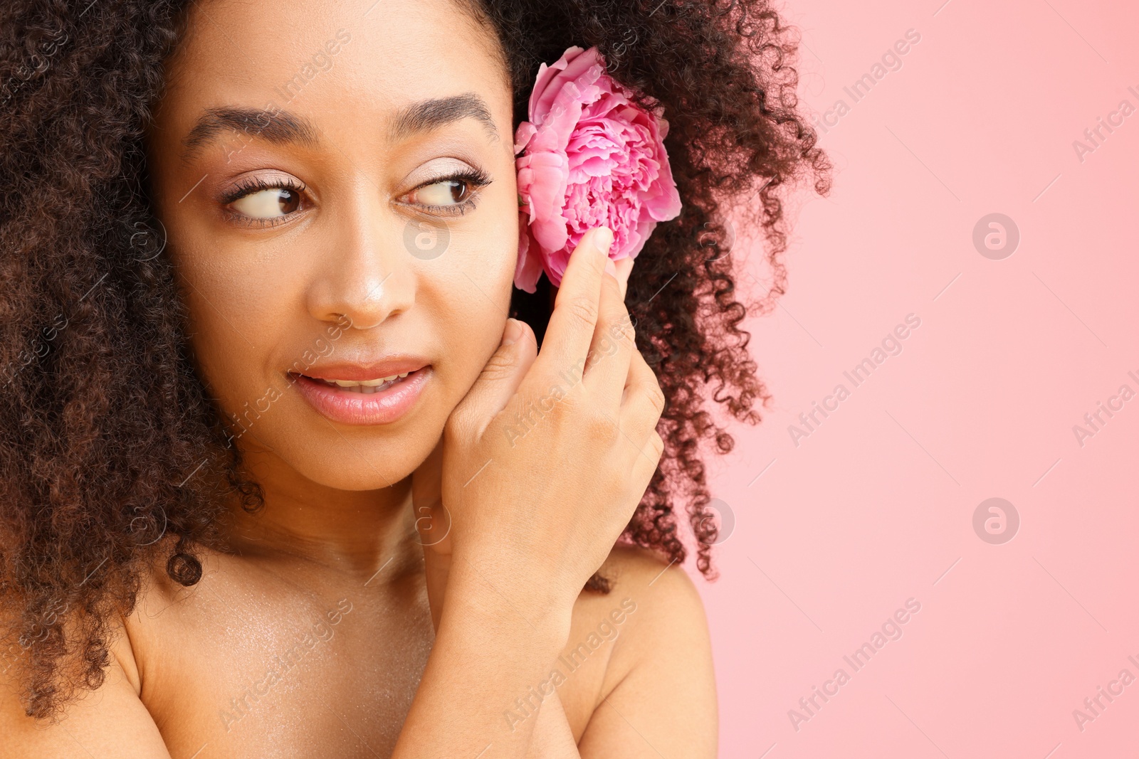 Beautiful Brazilian woman with peony flower on pink background, closeup. Space for text Photo of Beautiful Brazilian woman with peony flower on pink background, closeup. Space for text