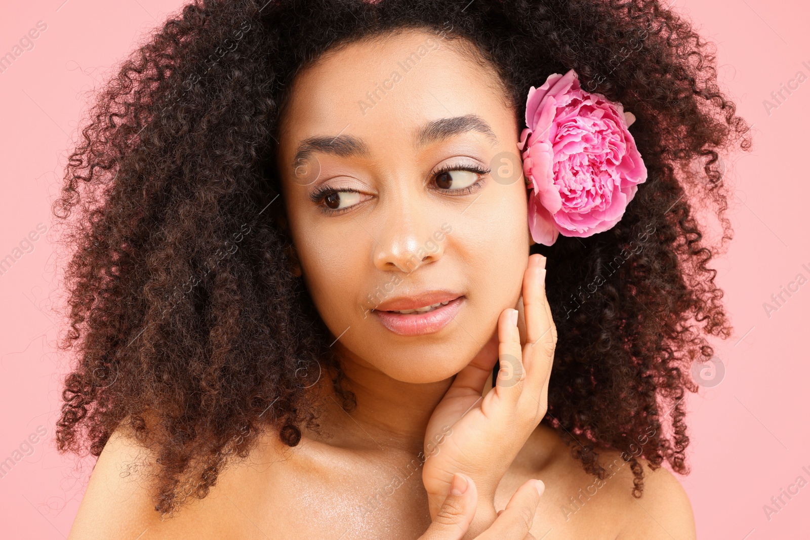 Beautiful Brazilian woman with peony flower on pink background, closeup Photo of Beautiful Brazilian woman with peony flower on pink background, closeup