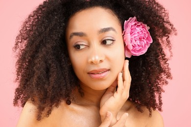 Photo of Beautiful Brazilian woman with peony flower on pink background, closeup