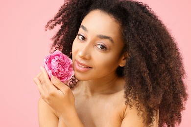Photo of Beautiful Brazilian woman with peony flower on pink background