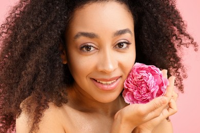 Photo of Beautiful Brazilian woman with peony flower on pink background, closeup
