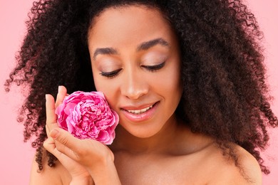 Photo of Beautiful Brazilian woman with peony flower on pink background, closeup