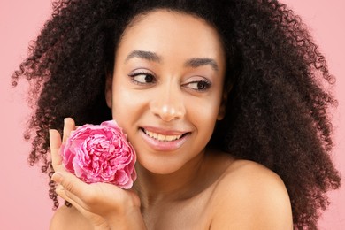 Photo of Beautiful Brazilian woman with peony flower on pink background, closeup