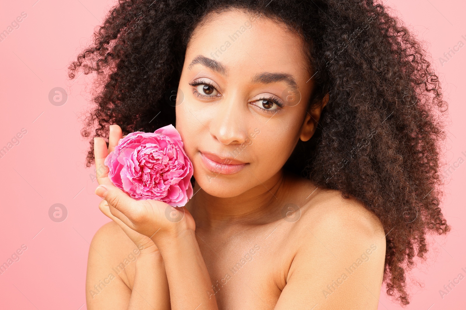 Beautiful Brazilian woman with peony flower on pink background, closeup Photo of Beautiful Brazilian woman with peony flower on pink background, closeup