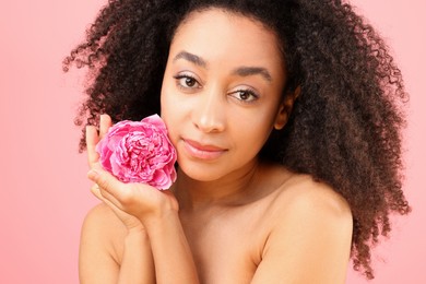 Photo of Beautiful Brazilian woman with peony flower on pink background, closeup