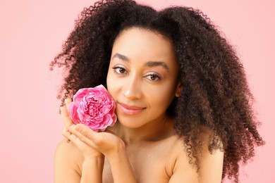 Photo of Beautiful Brazilian woman with peony flower on pink background