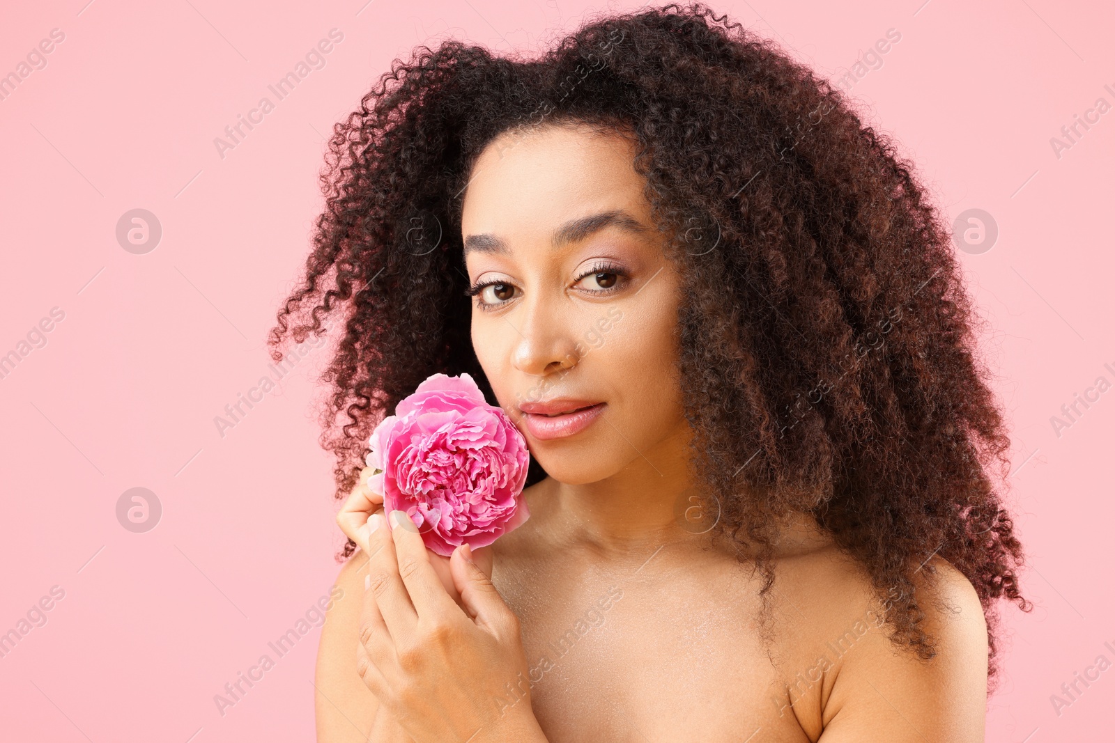 Beautiful Brazilian woman with peony flower on pink background Photo of Beautiful Brazilian woman with peony flower on pink background