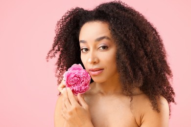 Photo of Beautiful Brazilian woman with peony flower on pink background