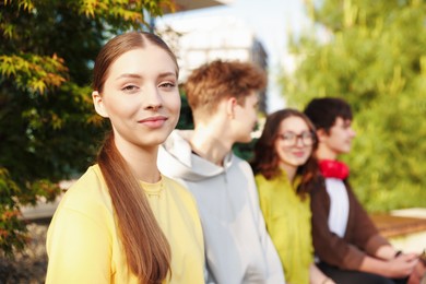 Photo of Teenagers spending time together in park, selective focus