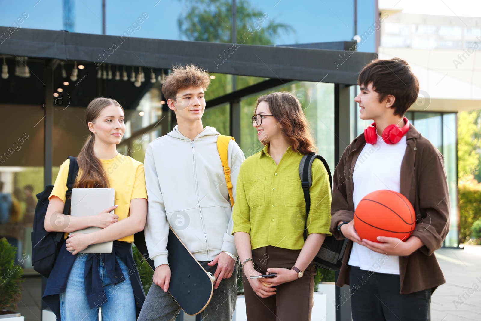 Group of teenagers spending time together outdoors Photo of Group of teenagers spending time together outdoors