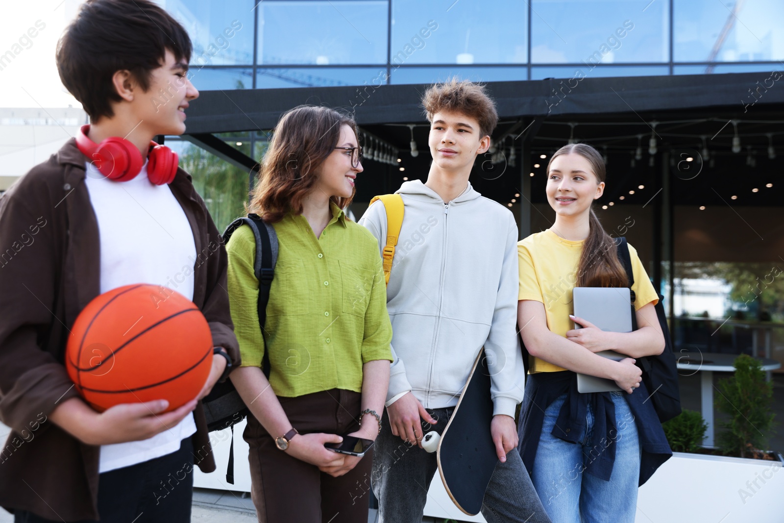 Group of teenagers spending time together outdoors Photo of Group of teenagers spending time together outdoors