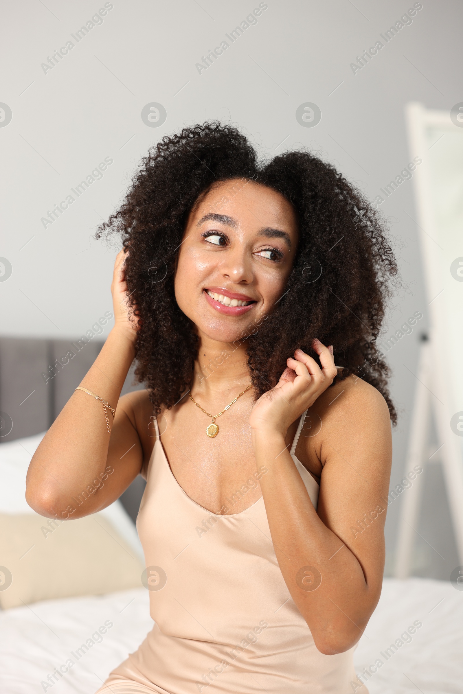 Beautiful smiling Brazilian woman with curly hair indoors Photo of Beautiful smiling Brazilian woman with curly hair indoors