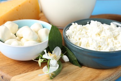 Photo of Different fresh dairy products and flowers on table, closeup