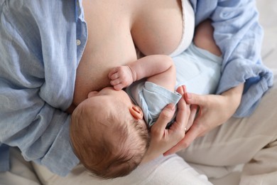 Photo of Mother breastfeeding her newborn baby indoors, above view