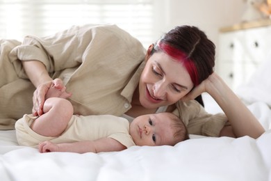 Photo of Mother with her newborn baby on bed indoors