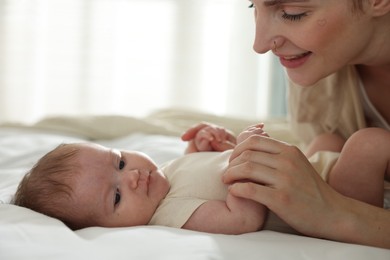 Photo of Mother with her newborn baby on bed indoors