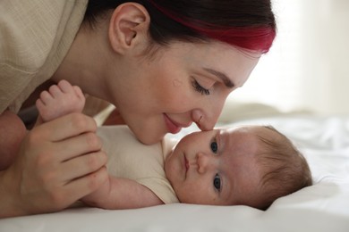Photo of Mother with her newborn baby on bed indoors