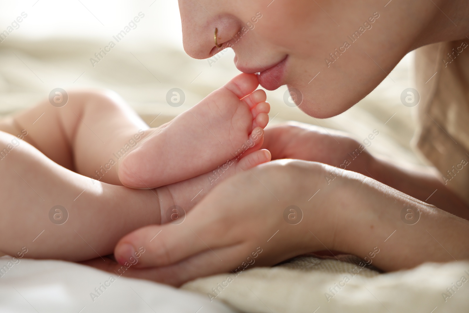 Mother with her newborn baby on bed indoors, closeup Photo of Mother with her newborn baby on bed indoors, closeup