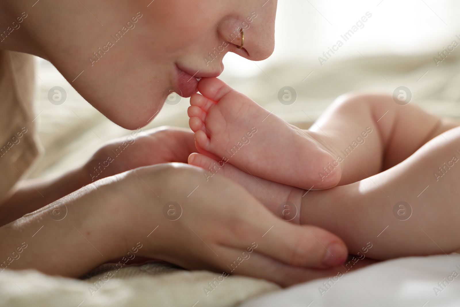Mother with her newborn baby on bed indoors, closeup Photo of Mother with her newborn baby on bed indoors, closeup