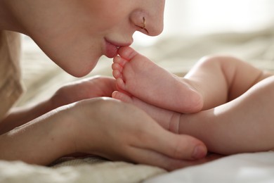 Photo of Mother with her newborn baby on bed indoors, closeup