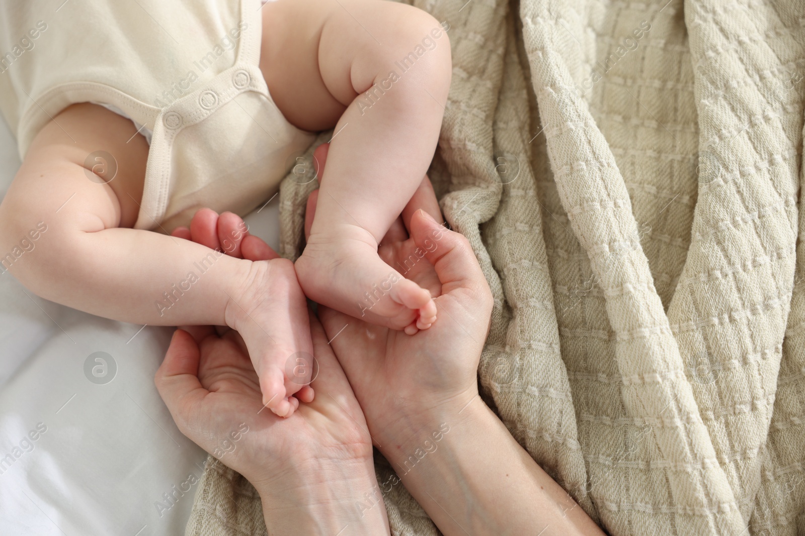 Mother with her newborn baby on bed indoors, top view Photo of Mother with her newborn baby on bed indoors, top view
