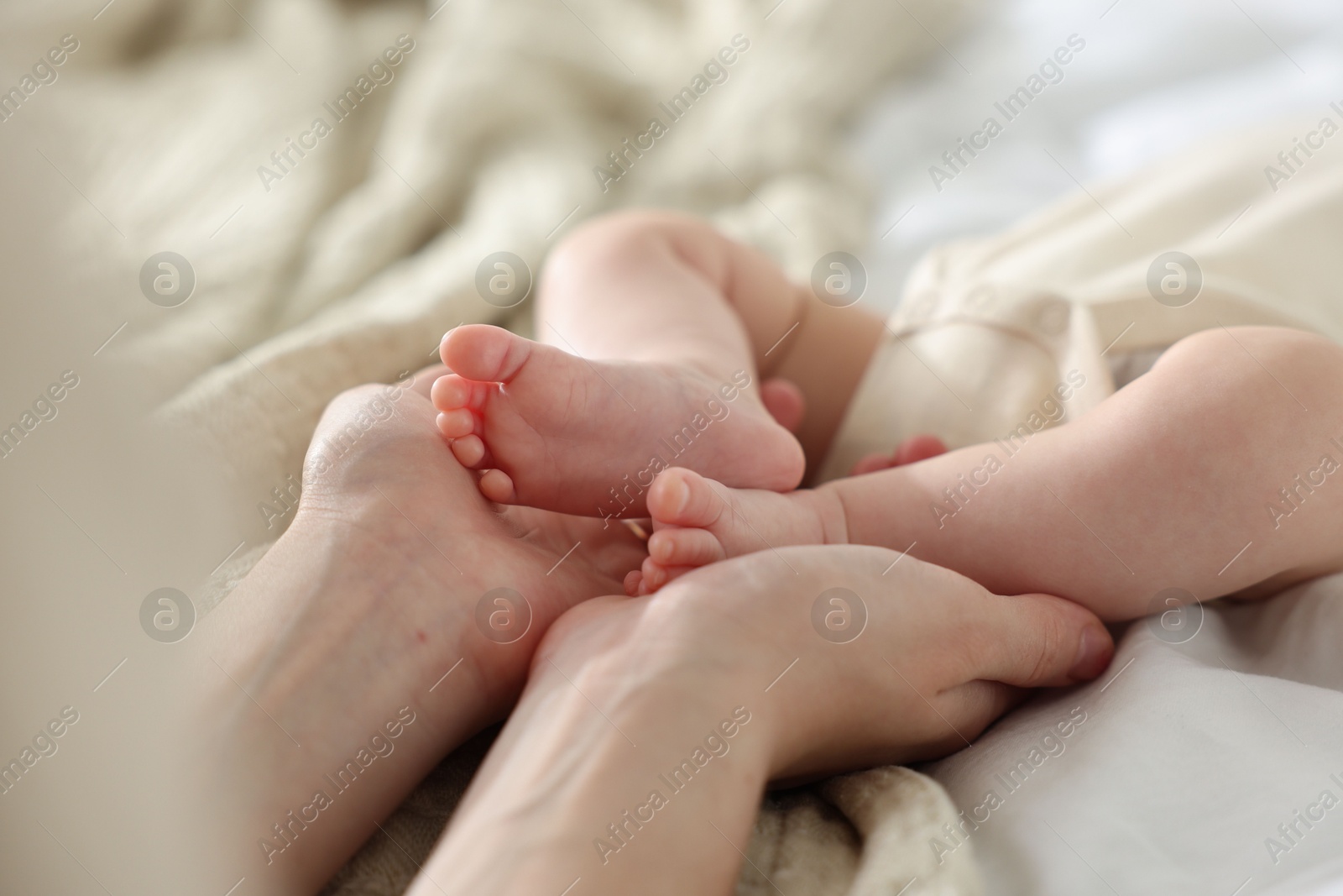 Mother with her newborn baby on bed indoors, closeup Photo of Mother with her newborn baby on bed indoors, closeup