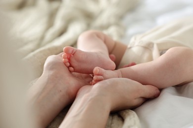 Photo of Mother with her newborn baby on bed indoors, closeup