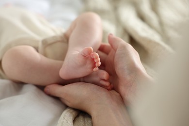 Photo of Mother with her newborn baby on bed indoors, closeup