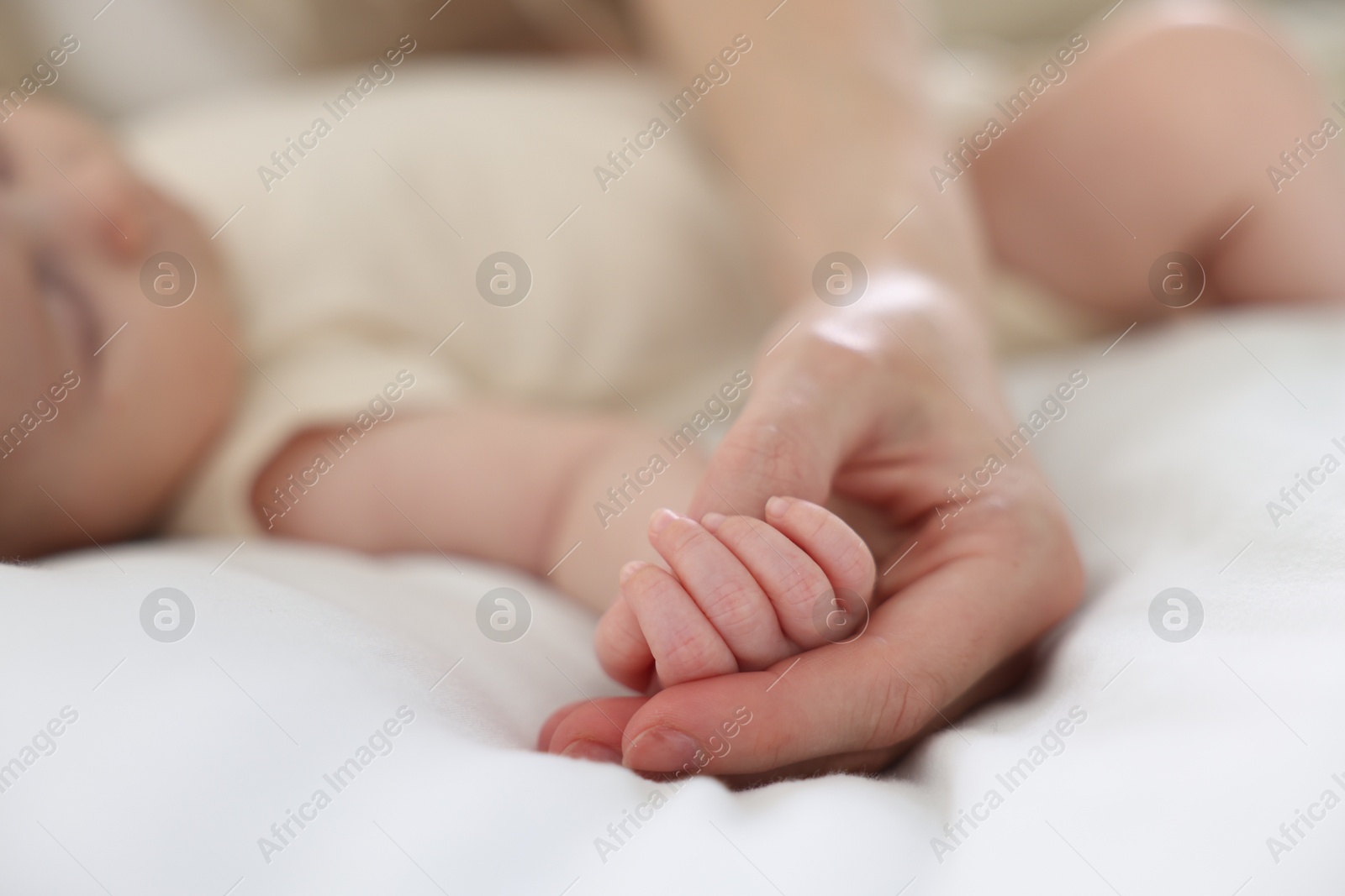 Mother with her newborn baby on bed indoors, closeup Photo of Mother with her newborn baby on bed indoors, closeup