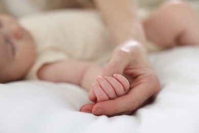 Photo of Mother with her newborn baby on bed indoors, closeup